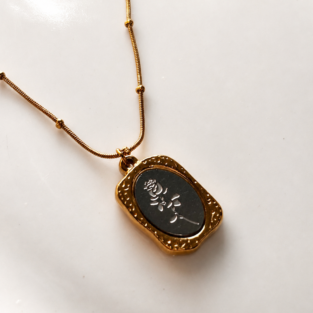 Necklace with a black pendant on a white background