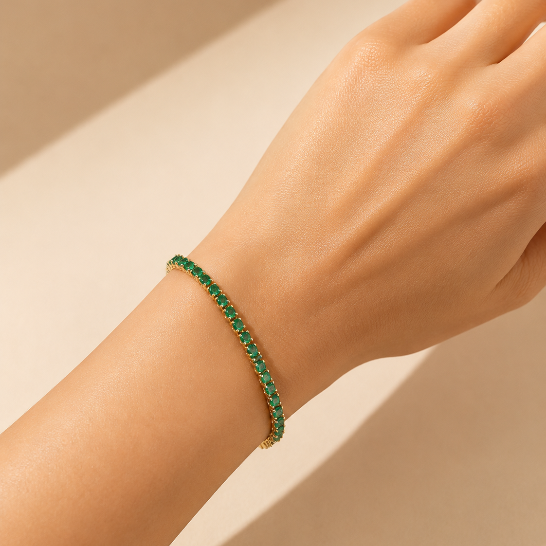 Green bracelet on a person's wrist against a beige background