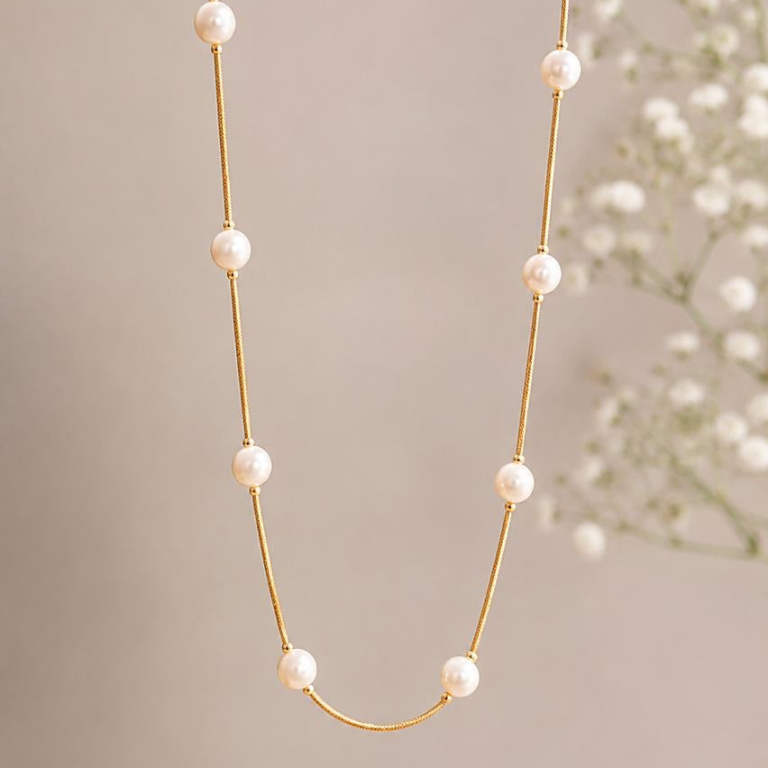 Pearl necklace with gold chain on a neutral background
