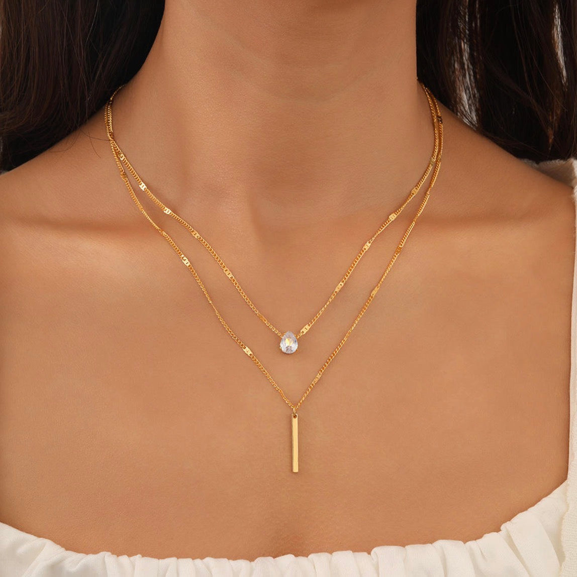 Gold necklaces on a person's neck with a blurred background