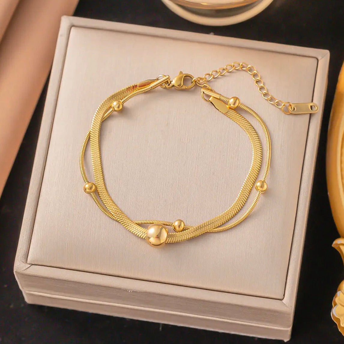 Gold bracelet on a beige jewelry box