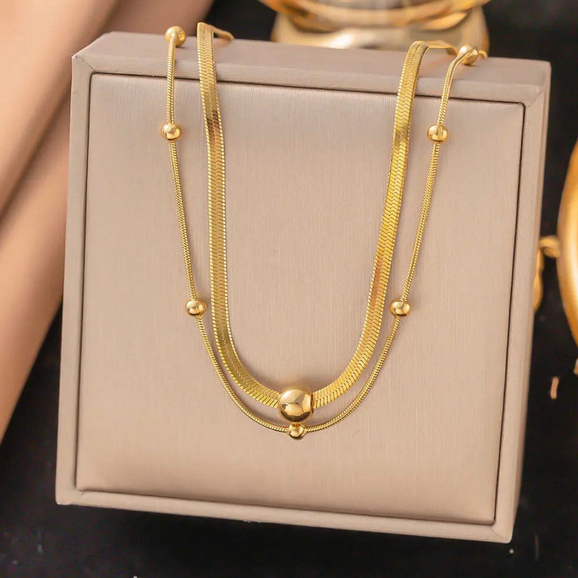 Gold necklace on a beige jewelry box