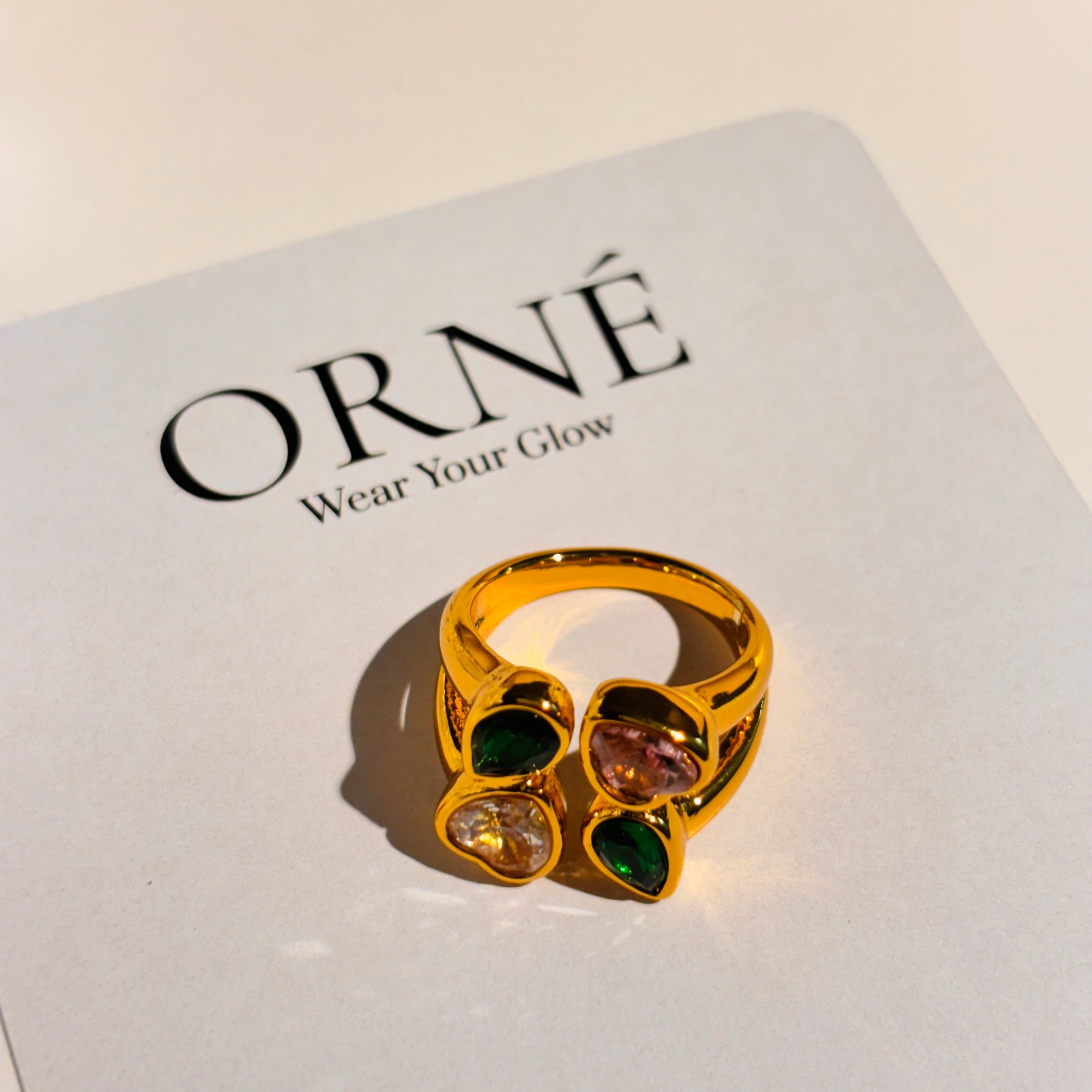 Gold ring with colored stones on a 'Orne' branded card