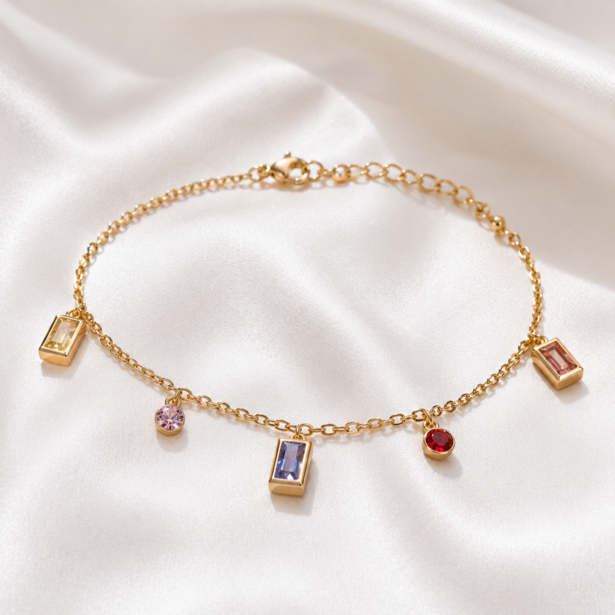 Gold bracelet with colorful gemstone charms on a satin background