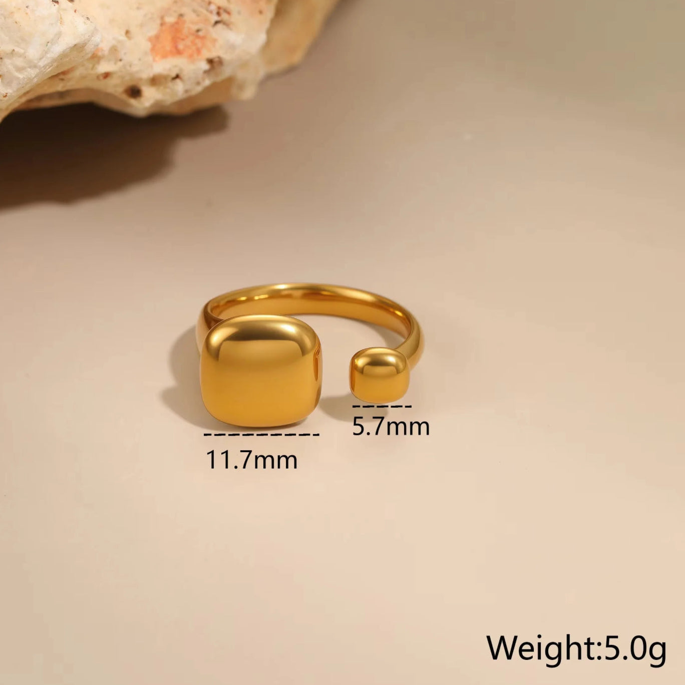 Gold ring with measurements on a beige background