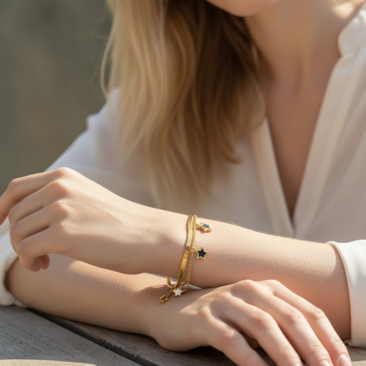 Close-up of a person wearing gold bracelets on a blurred background